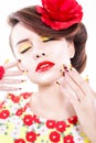 Brunette woman in yellow and red dress with poppy flower in her hair, poppy ring and creative nails, closed eyes