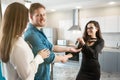 Brunette woman realtor property manager giving keys to lovely satisfied clients couple man and woman shaking hands at cosy