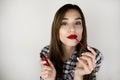 Brunette young woman applying red lipstick on her lips looking sexy, beauty and makeup  white background Royalty Free Stock Photo