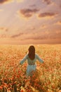 Brunette woman walking through flower meadow. Royalty Free Stock Photo