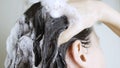 Brunette young woman washing head with shampoo with foam closeup Royalty Free Stock Photo