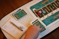 Brunswick, Germany - September 25, 2022: Playing field of the famouse board game Activity. Player`s hand is taking the card.