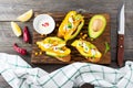 Bruschetta with avocado, yellow pepper, grains of corn, parsley and chili pepper on a light wooden background.