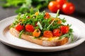 bruschetta with baby arugula, cherry tomatoes on ceramic plate