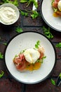 Bruschetta with cream cheese, wilde rucola, parma ham and poached egg served on white plate. Royalty Free Stock Photo