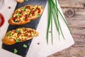 Bruschetta with feta cheese, dried tomatoes, olive oil and fresh microgreen herbs, on a stone plate on a wooden table.