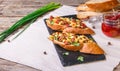 Bruschetta with feta cheese, dried tomatoes, olive oil and fresh microgreen herbs, on a stone plate on a wooden table. Royalty Free Stock Photo