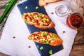 Bruschetta with feta cheese, dried tomatoes, olive oil and fresh microgreen herbs, on a stone plate on a wooden table. Royalty Free Stock Photo