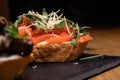 Bruschetta from a French loaf with salmon, cheese and arugula. Snacks and sandwiches