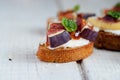 Bruschetta with goat cheese and figs on white wooden table Royalty Free Stock Photo