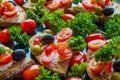 Bruschetta with green and black olives, feta cheese, cherry tomatoes, parsley and red pepper on black background Royalty Free Stock Photo