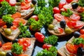 Bruschetta with green and black olives, feta cheese, cherry tomatoes, parsley and red pepper on black background Royalty Free Stock Photo