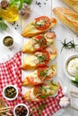 Bruschetta, grilled slices of baguette with mozzarella cheese, tomatoes, garlic and aromatic basil on a white wooden table