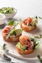 Bruschetta with ham or prosciutto, cream cheese, cucumber, spinach and microgreens. Tasty sandwich or toasted bread on Royalty Free Stock Photo