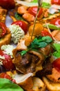 Homemade bruschetta with honey agaric, mozzarella, pesto, bacon, salad leafs, tomatoes, cream on white table