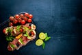 Bruschetta with meat, olives, herbs and parmesan cheese on bread. Cold snacks. Italian cuisine. Royalty Free Stock Photo