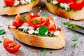 Bruschetta with pesto sauce, feta cheese, tomatoes and basil