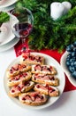 Bruschetta with prosciutto on Christmas celebration dinner table. Festive place setting for holiday with natural decorations from Royalty Free Stock Photo