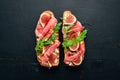 Bruschetta with prosciutto, fresh figs and cheese. On the old background. Healthy food. Free space for text. Royalty Free Stock Photo