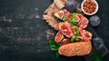 Bruschetta with prosciutto, fresh figs and cheese. On the old background. Healthy food. Free space for text. Royalty Free Stock Photo