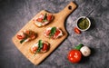 Bruschetta with prosciutto, pesto, mozzarella and tomatoes.