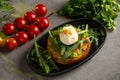 Bruschetta salmon with avocado - salted salmon with guacamole, arugula and poached egg on a warm fried bun