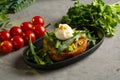 Bruschetta salmon with avocado - salted salmon with guacamole, arugula and poached egg on a warm fried bun