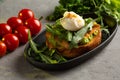 Bruschetta salmon with avocado - salted salmon with guacamole, arugula and poached egg on a warm fried bun