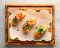Bruschetta with salmon on wood top view. Smoked salmon toast with guacamole and microgreen