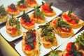 Bruschetta with shrimps, basil, pesto and mozzarella sauce and tomato on a white plate on a wooden background. Italian restaurant Royalty Free Stock Photo