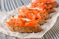 Bruschetta with smoked salmon and camembert on crumpled baking paper
