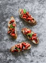 Bruschetta with strawberries, cream cheese and balsamic sauce on a grey background, top view. Delicious appetizer, tapas
