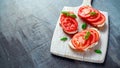 Bruschetta, toast with soft cheese, basil and tomatoes on a white wooden board. Italian healthy snack, food. Royalty Free Stock Photo