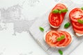 Bruschetta, toast with soft cheese, basil and tomatoes on a white wooden board. Italian healthy snack, food. Royalty Free Stock Photo