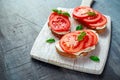 Bruschetta, toast with soft cheese, basil and tomatoes on a white wooden board. Italian healthy snack, food. Royalty Free Stock Photo