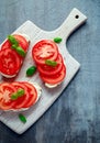 Bruschetta, toast with soft cheese, basil and tomatoes on a white wooden board. Italian healthy snack, food. Royalty Free Stock Photo
