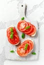 Bruschetta, toast with soft cheese, basil and tomatoes on a white wooden board. Italian healthy snack, food. Royalty Free Stock Photo