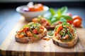 bruschetta on toasted baguette slices with whole plum tomatoes and basil on side