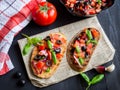Bruschetta with Tomato and Basil on black wooden boards.