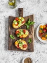 Bruschetta with tomatoes and avocado on rustic wooden cutting board. Delicious snack