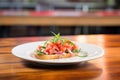 bruschetta with a topping of tomato, basil, and red onion on a glass plate Royalty Free Stock Photo