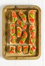 Bruschetta: traditional italian appetizer with tomatoes, basil leaves and olive oil on cutting board. Top view Royalty Free Stock Photo