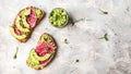 Bruschetta with watermelon radish and avocado. Delicious breakfast or snack on a light background, top view