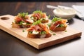 bruschettas with prosciutto and arugula on wooden board