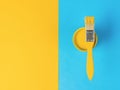 A brush with bright yellow paint on a blue and yellow background. Trending colors Royalty Free Stock Photo