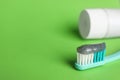 Brush with charcoal toothpaste on green background, closeup. Space for text Royalty Free Stock Photo