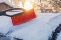 brush for cleaning the car from snow on the background of sunbeams. Winter, snow, cold, frost. horizontal ph. close-up.