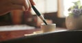 Brush, closeup and hands at a table for calligraphy, writing or ancient Japanese art in a house. Letter, communication Royalty Free Stock Photo