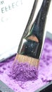 Brush dipped in purple eyeshadow - macro Royalty Free Stock Photo