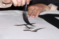 Brush drawing a hieroglyph with black ink on white rice paper